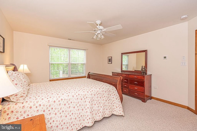 bedroom featuring baseboards, ceiling fan, and light colored carpet