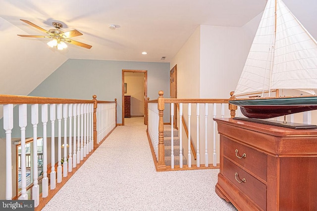 corridor featuring light colored carpet, an upstairs landing, lofted ceiling, and recessed lighting