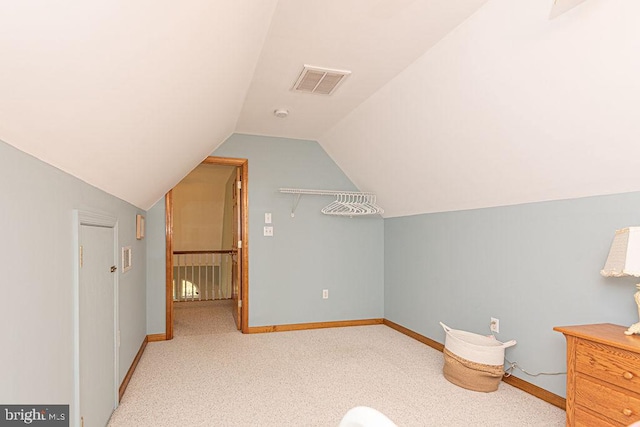 additional living space featuring vaulted ceiling, carpet floors, baseboards, and visible vents