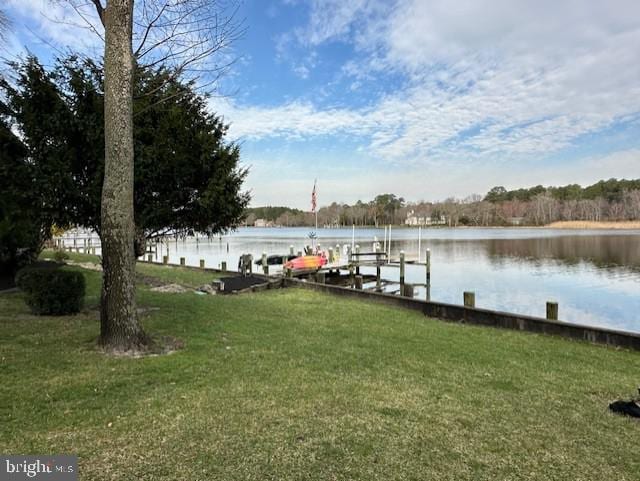 dock area featuring boat lift, a water view, and a yard