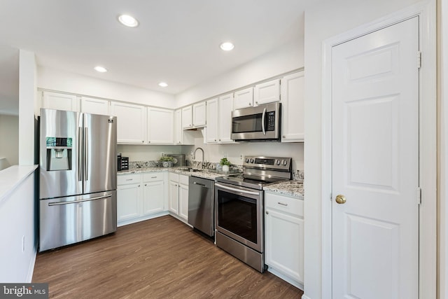 kitchen featuring white cabinetry, stainless steel appliances, dark wood finished floors, and a sink