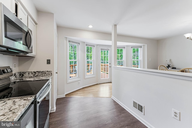 kitchen featuring appliances with stainless steel finishes, wood finished floors, visible vents, and a healthy amount of sunlight