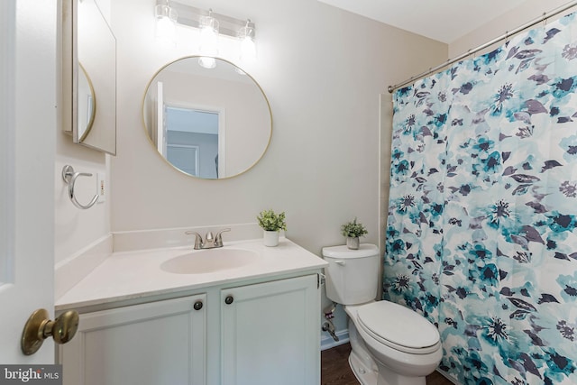 bathroom with toilet, curtained shower, and vanity
