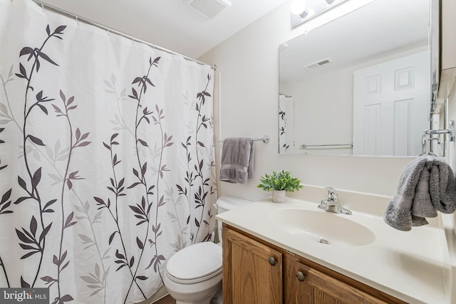 bathroom with visible vents, toilet, and vanity