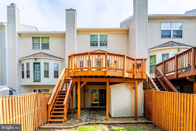 back of property featuring a deck, a fenced backyard, and stairs