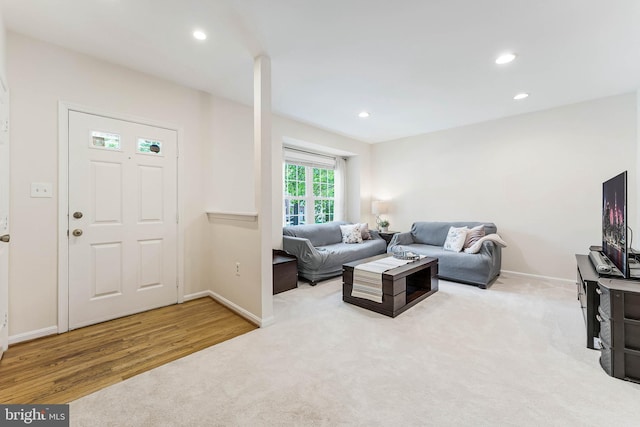 carpeted living room with recessed lighting, wood finished floors, and baseboards
