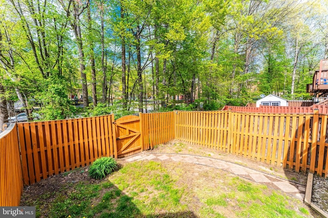 view of yard with a fenced backyard and a gate