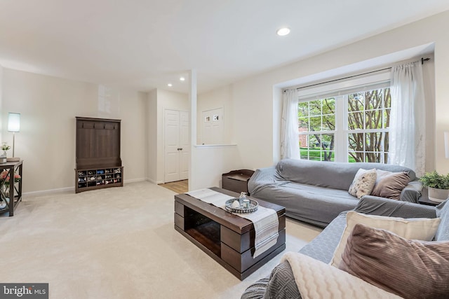 living area featuring baseboards, recessed lighting, and light colored carpet
