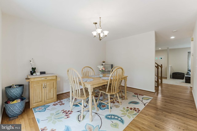 dining space with an inviting chandelier, wood finished floors, recessed lighting, and baseboards