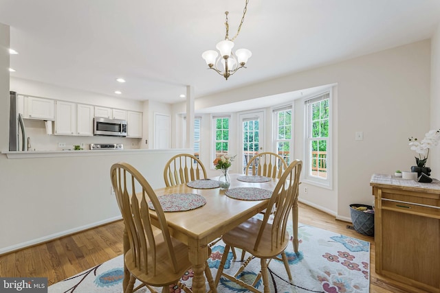 dining room featuring an inviting chandelier, recessed lighting, light wood-style flooring, and baseboards