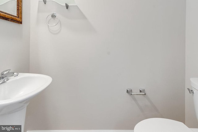 half bath featuring toilet and a sink
