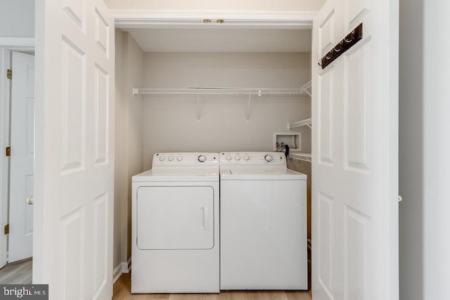 clothes washing area featuring separate washer and dryer and laundry area