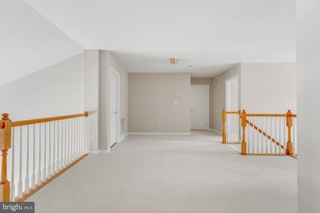 interior space with carpet floors, an upstairs landing, visible vents, and baseboards