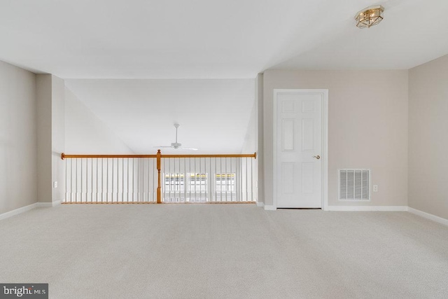 carpeted empty room with visible vents, baseboards, and ceiling fan