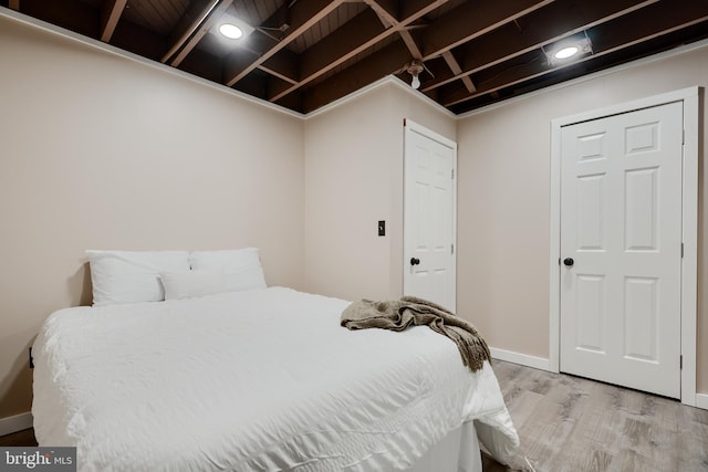 bedroom with light wood finished floors and baseboards