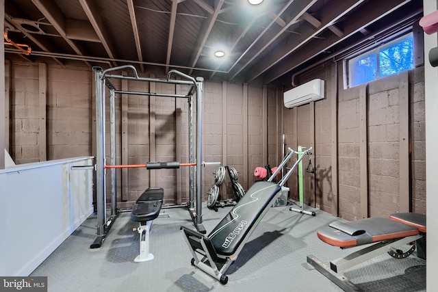 exercise area featuring an AC wall unit and concrete block wall