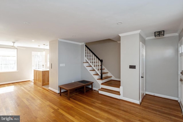 interior space featuring baseboards, recessed lighting, wood finished floors, and crown molding