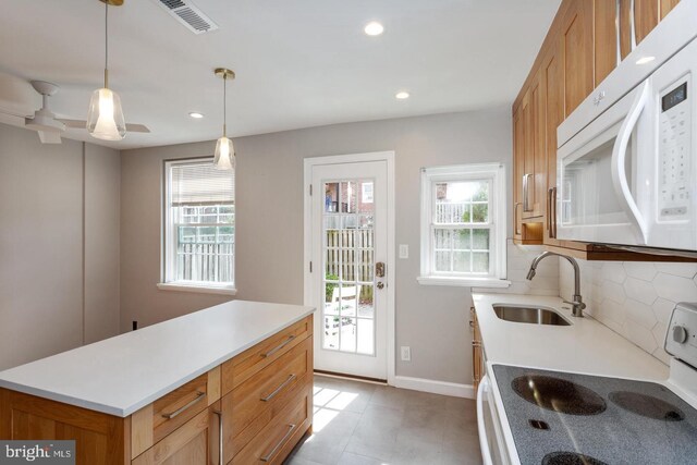 kitchen featuring light tile patterned floors, a sink, recessed lighting, white appliances, and backsplash