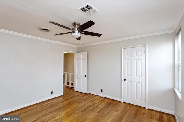 unfurnished bedroom with baseboards, visible vents, ornamental molding, and wood-type flooring