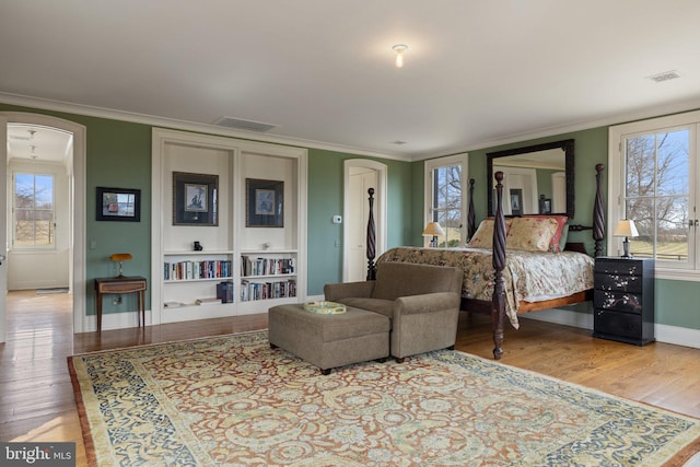 9425 Blackpond Ln, Delaplane, VA 20144 - bedroom featuring arched walkways, crown molding, baseboards, wood finished floors, and multiple windows