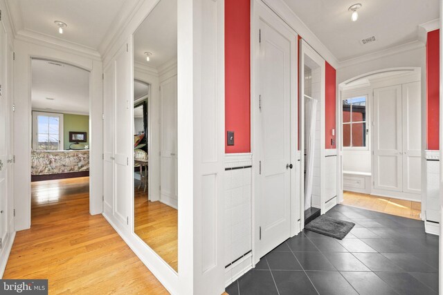 9425 Blackpond Ln, Delaplane, VA 20144 - hallway featuring arched walkways, ornamental molding, a decorative wall, a wainscoted wall, and tile patterned flooring