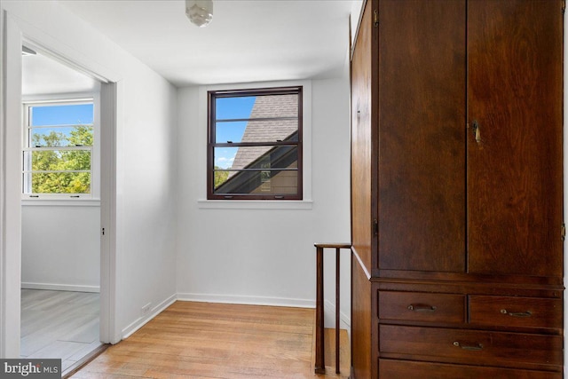 interior space featuring baseboards, a healthy amount of sunlight, and light wood-style flooring
