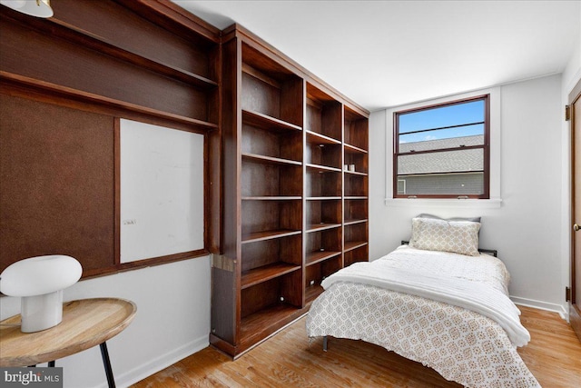 bedroom with baseboards and wood finished floors