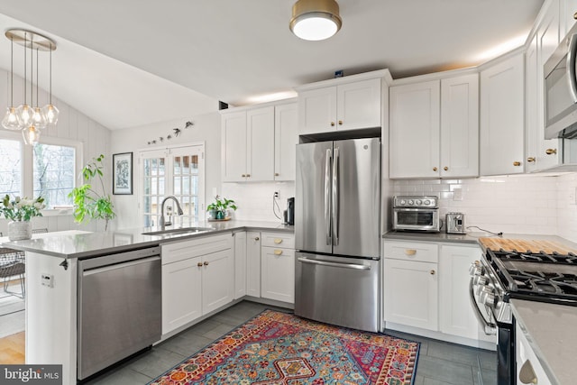 4600 Blagden Ter NW, Washington, DC 20011 - kitchen featuring appliances with stainless steel finishes, a sink, decorative backsplash, white cabinets, and vaulted ceiling
