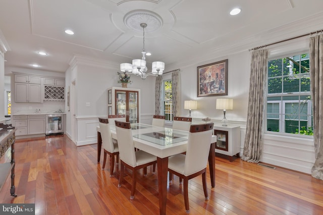 dining space with visible vents, an inviting chandelier, wine cooler, a wainscoted wall, and hardwood / wood-style floors