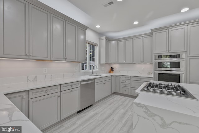 kitchen with visible vents, recessed lighting, a sink, stainless steel appliances, and gray cabinetry