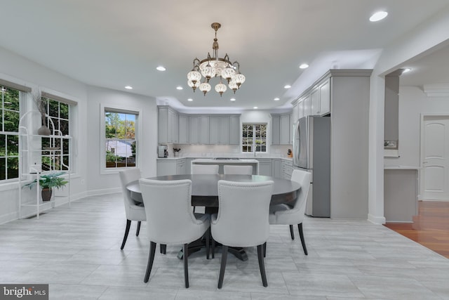 dining area with a wealth of natural light, recessed lighting, a notable chandelier, and baseboards