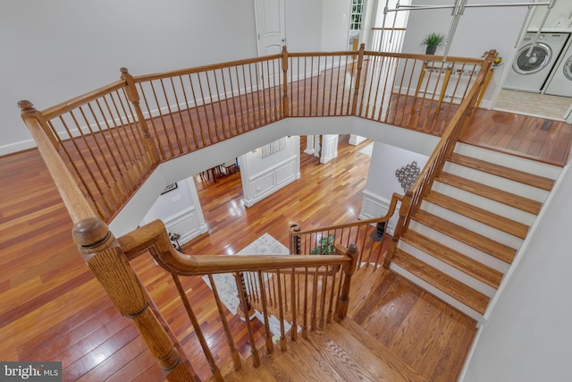 staircase with washer and dryer and hardwood / wood-style floors