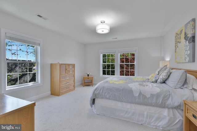 carpeted bedroom featuring visible vents, multiple windows, and baseboards