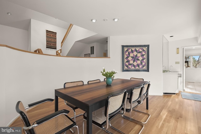 dining room featuring baseboards, recessed lighting, and light wood-style floors
