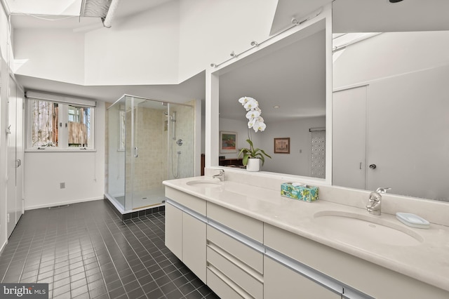 full bath with a shower stall, tile patterned flooring, a sink, and double vanity