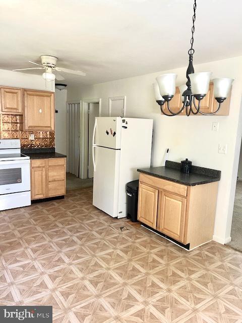 136 Charles Pl, Indian Head, MD 20640 - kitchen with dark countertops, ceiling fan with notable chandelier, light brown cabinetry, and white appliances