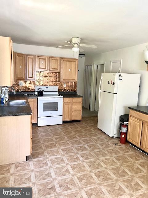 136 Charles Pl, Indian Head, MD 20640 - kitchen featuring a sink, decorative backsplash, a ceiling fan, white appliances, and dark countertops