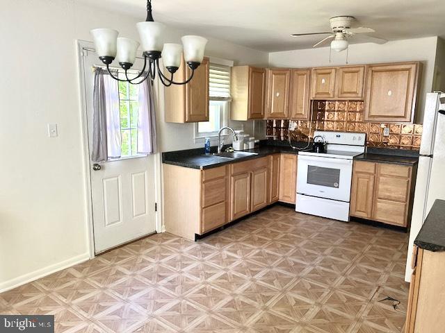 136 Charles Pl, Indian Head, MD 20640 - kitchen with decorative backsplash, ceiling fan with notable chandelier, dark countertops, a sink, and white electric range oven