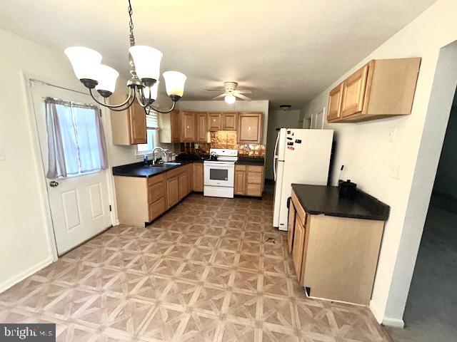 136 Charles Pl, Indian Head, MD 20640 - kitchen featuring a sink, white appliances, baseboards, dark countertops, and ceiling fan with notable chandelier