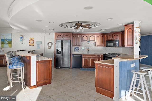 12201 Wight St Unit 301, Ocean City, MD 21842 - kitchen with light tile patterned floors, a kitchen bar, black appliances, a ceiling fan, and a peninsula
