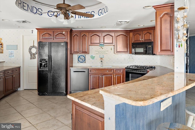 12201 Wight St Unit 301, Ocean City, MD 21842 - kitchen featuring light stone countertops, black appliances, a ceiling fan, visible vents, and a peninsula