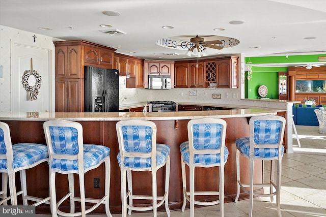 12201 Wight St Unit 301, Ocean City, MD 21842 - kitchen with ceiling fan, range, black fridge, and stainless steel microwave