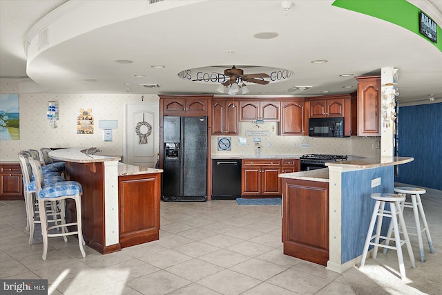 12201 Wight St Unit 301, Ocean City, MD 21842 - kitchen featuring a kitchen breakfast bar, light tile patterned floors, ceiling fan, black appliances, and a peninsula