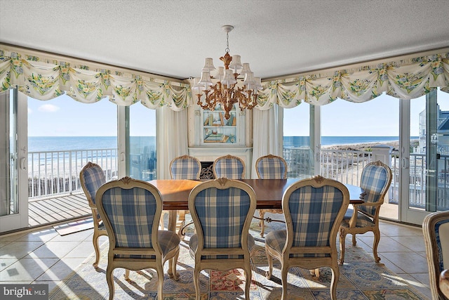 12201 Wight St Unit 301, Ocean City, MD 21842 - dining space featuring a notable chandelier, light tile patterned flooring, a water view, and a textured ceiling