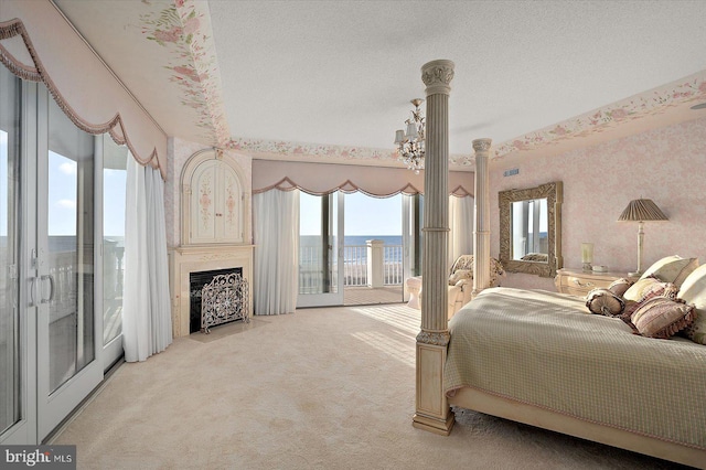 12201 Wight St Unit 301, Ocean City, MD 21842 - bedroom featuring light colored carpet, wallpapered walls, access to exterior, a textured ceiling, and a fireplace with flush hearth
