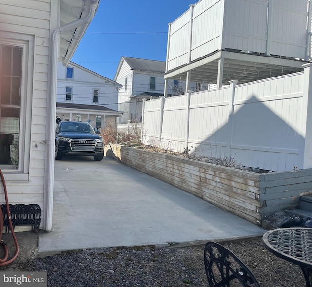 view of side of home with a residential view and fence