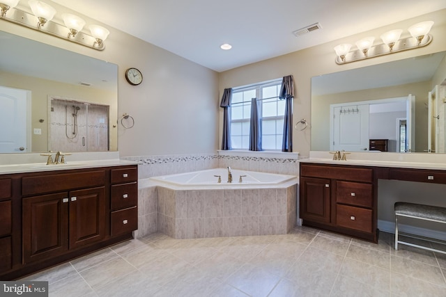 bathroom featuring visible vents, a bath, tile patterned floors, two vanities, and a sink