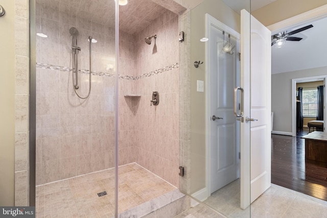 full bath with baseboards, tile patterned flooring, a ceiling fan, and a stall shower