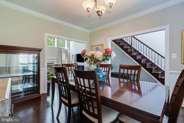 dining space with dark wood-type flooring, ornamental molding, stairs, and a chandelier