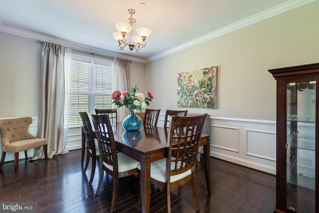 dining area featuring ornamental molding, dark wood finished floors, a wainscoted wall, and a notable chandelier